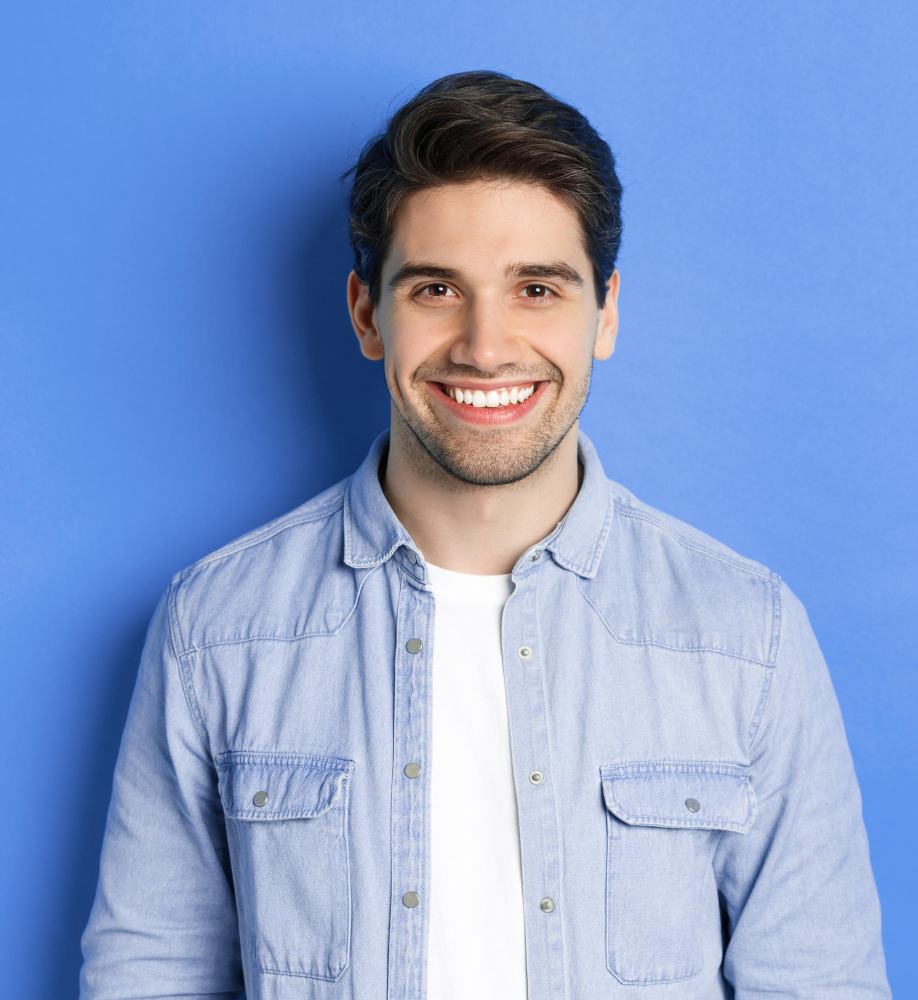 A smiling young man wearing a denim shirt against a blue background, representing the protection of a website.