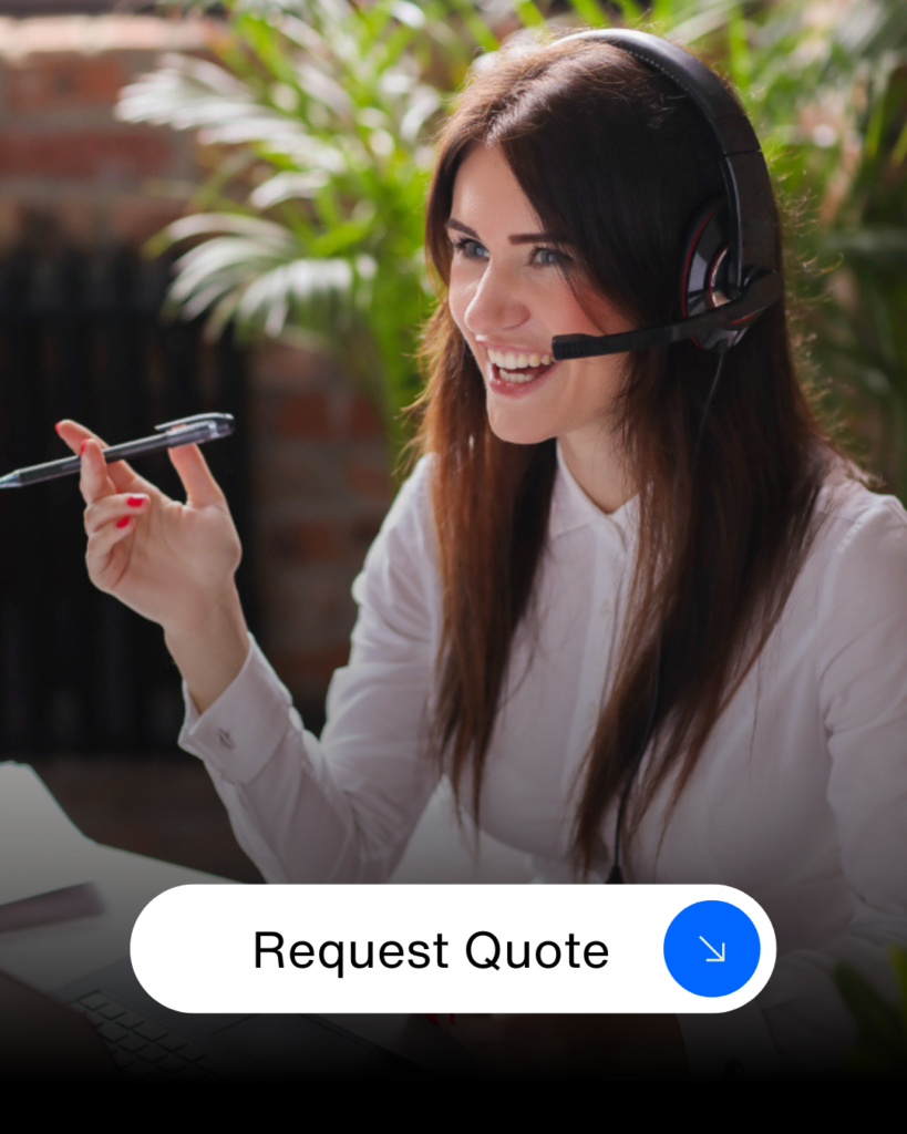 Customer service representative wearing a headset, smiling and holding a pen, ready to assist with pricing.